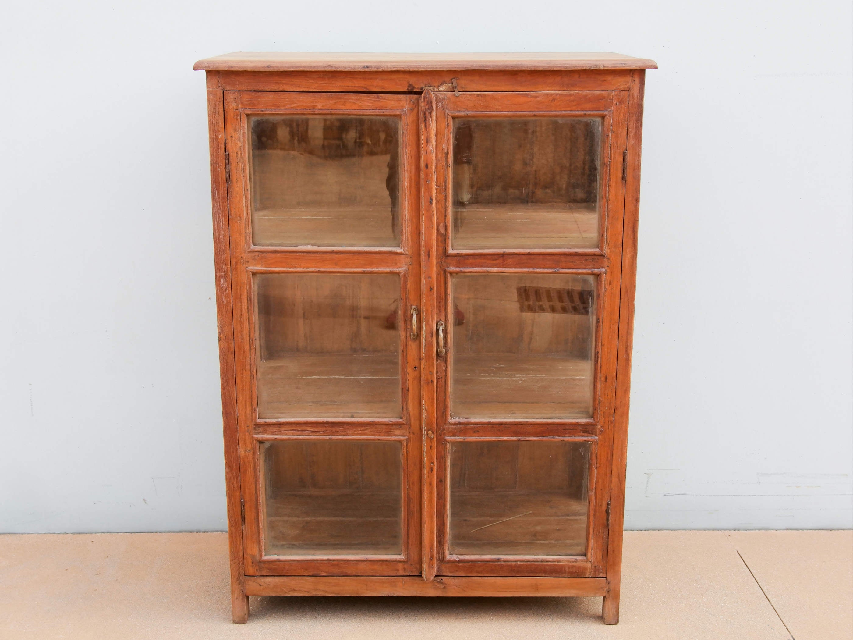 vetrinetta indiana in teak naturale, mobile coloniale 2 ante  databile prima metà 900  credenza, cassettiera etnica assemblata artigianalmente , pezzo unico lavorato a mano .  particolare ed unica perchè con vetri laterali e frontali . dimensioni 96 x 50 h. 132  cm