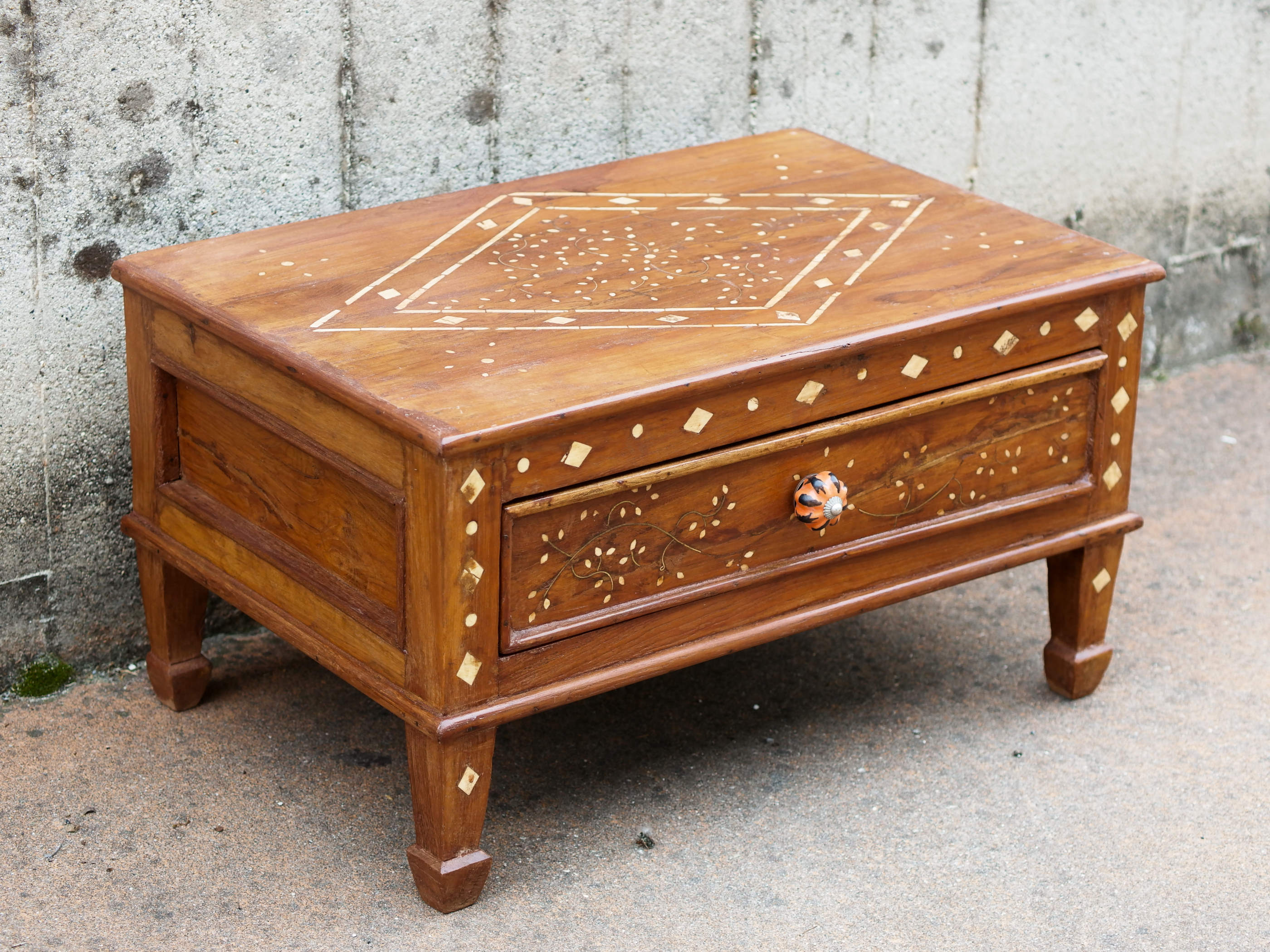 Tavolino Indiano con cassetto, in legno di teak con intarsi in osso. Pezzo unico di finitura artigianale .  Dimensioni 61x40 h34cm