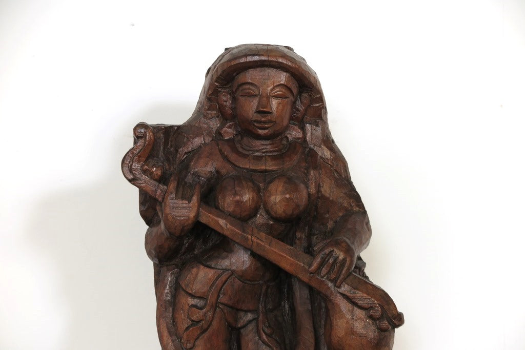 Statua Sarasvati in legno , tronco di teak inciso , 30x15h.70 databile metà 900 , pezzo unico lavorato artigianalmente . Sarasvatī è venerata sin dall'epoca vedica come dea della conoscenza e delle arti, della letteratura, musica, pittura e poesia, ma anche della verità, del perdono, delle guarigioni e delle nascite Nel Vedānta viene invece citata come energia femminile e aspetto (shakti) di Brahmā, in particolare come personificazione della sua conoscenza; come nei testi più antichi, è venerata anche come 