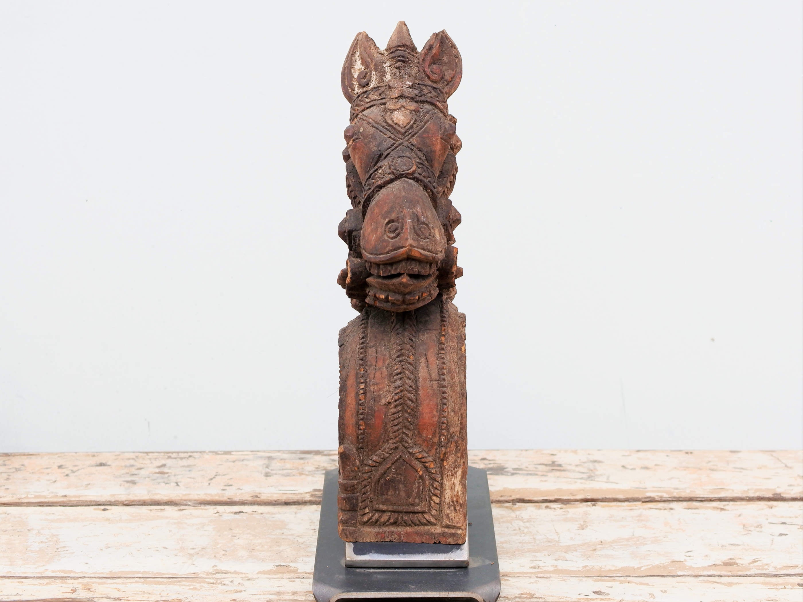 Antica statua indiana raffigurante un cavallo in legno di teak inciso con basamento in metallo. Si nota la patina del tempo e l'usura naturale dell'oggetto. Unico e conservato perfettamente é databile primi 900. dimensioni 15x33 h44cm