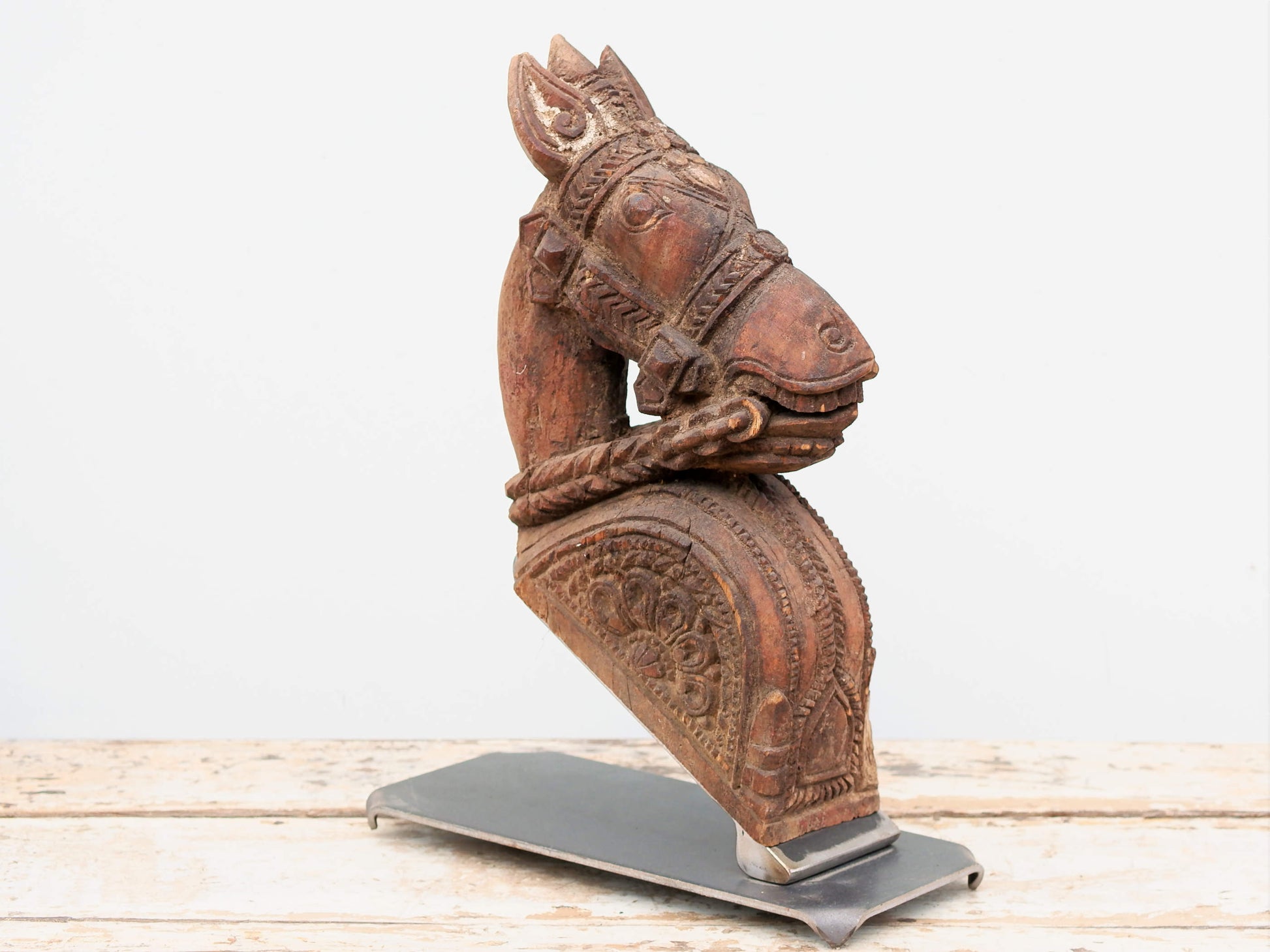 Antica statua indiana raffigurante un cavallo in legno di teak inciso con basamento in metallo. Si nota la patina del tempo e l'usura naturale dell'oggetto. Unico e conservato perfettamente é databile primi 900. dimensioni 15x33 h44cm