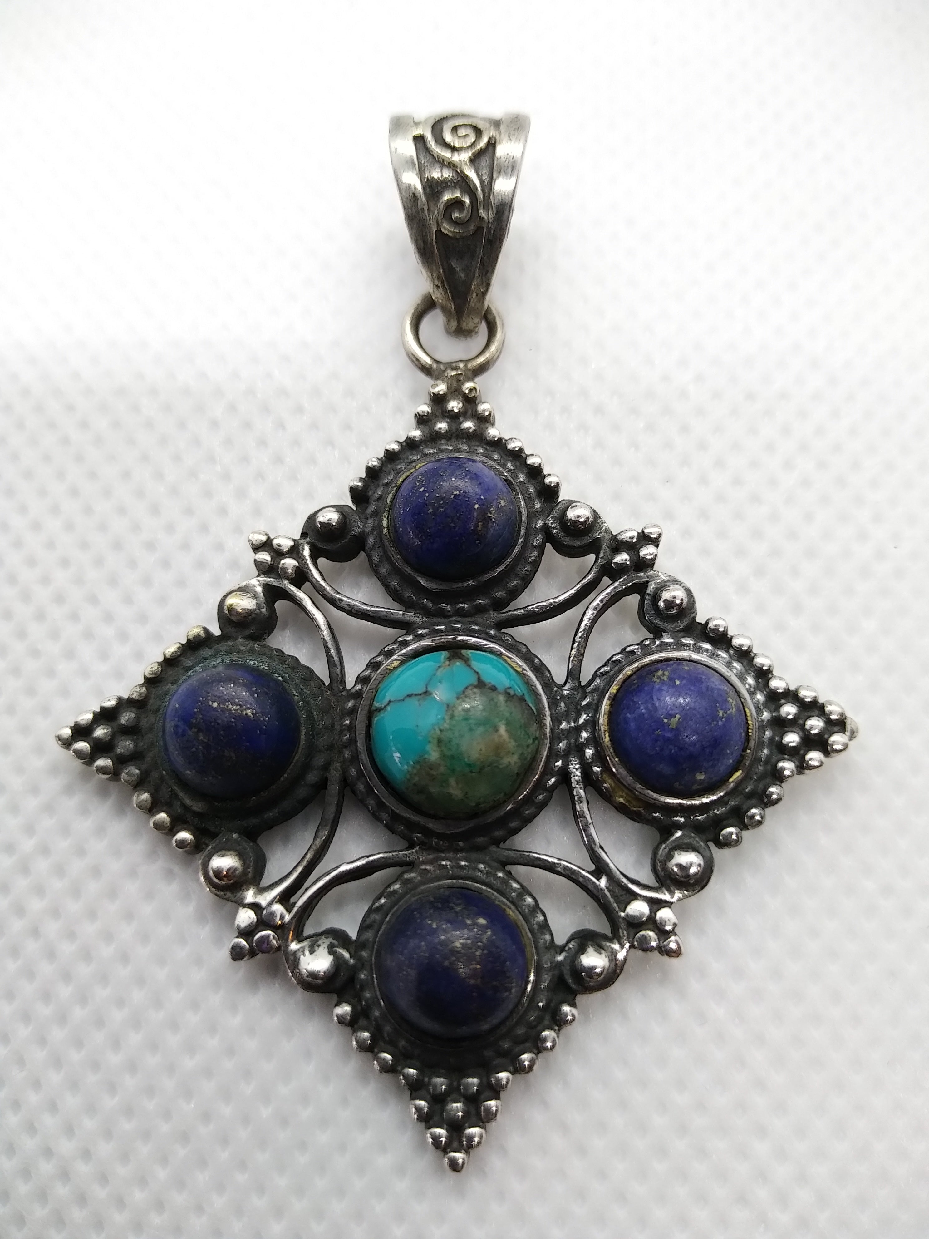 pendaglio tibetano / nepalese in argento 800 con turchesi e lapislazzulo  pezzo unico lavorato artigianalmente tutto originale ed autentico .   peso 15gr  dimensioni 4,3x4,3 cm