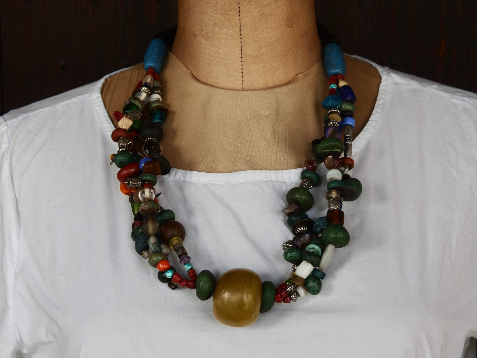 Collana tribale Amazigh, Berbera. Fatta a mano da artigiani berberi tradizionali con perline in ceramica, cristalli, pelle, pietre, corna, resine vegetali naturali e alcune piccole monete vecchie. La pietra centrale di un colore giallo intenso è di diametro 4cm circa, è leggermente ovalizzata. Pezzo unico di origine tribale , disponibili altri modelli oltre a quelli fotografati.  lunghezza 80cm, peso 230 gr