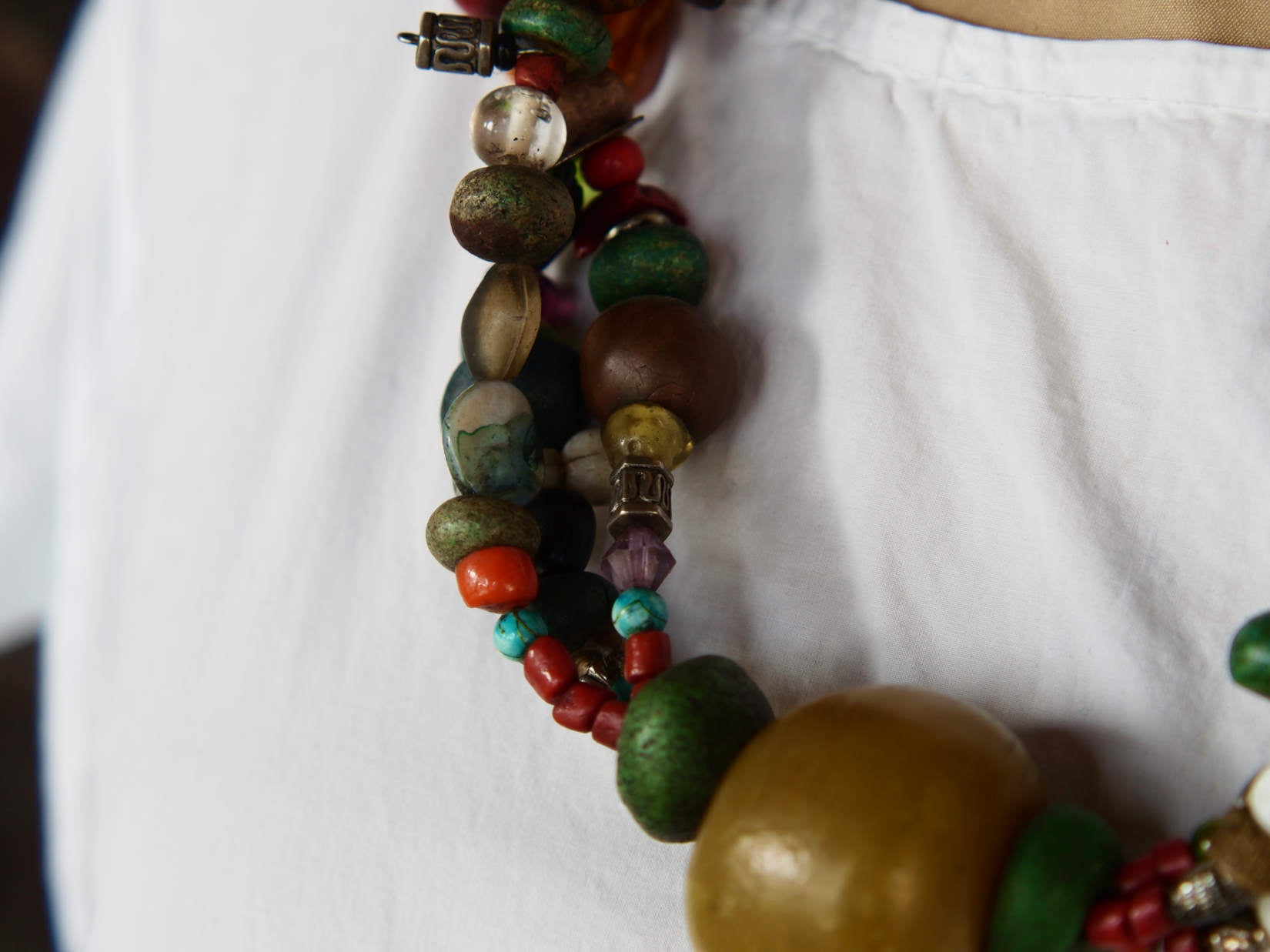 Collana tribale Amazigh, Berbera. Fatta a mano da artigiani berberi tradizionali con perline in ceramica, cristalli, pelle, pietre, corna, resine vegetali naturali e alcune piccole monete vecchie. La pietra centrale di un colore giallo intenso è di diametro 4cm circa, è leggermente ovalizzata. Pezzo unico di origine tribale , disponibili altri modelli oltre a quelli fotografati.  lunghezza 80cm, peso 230 gr