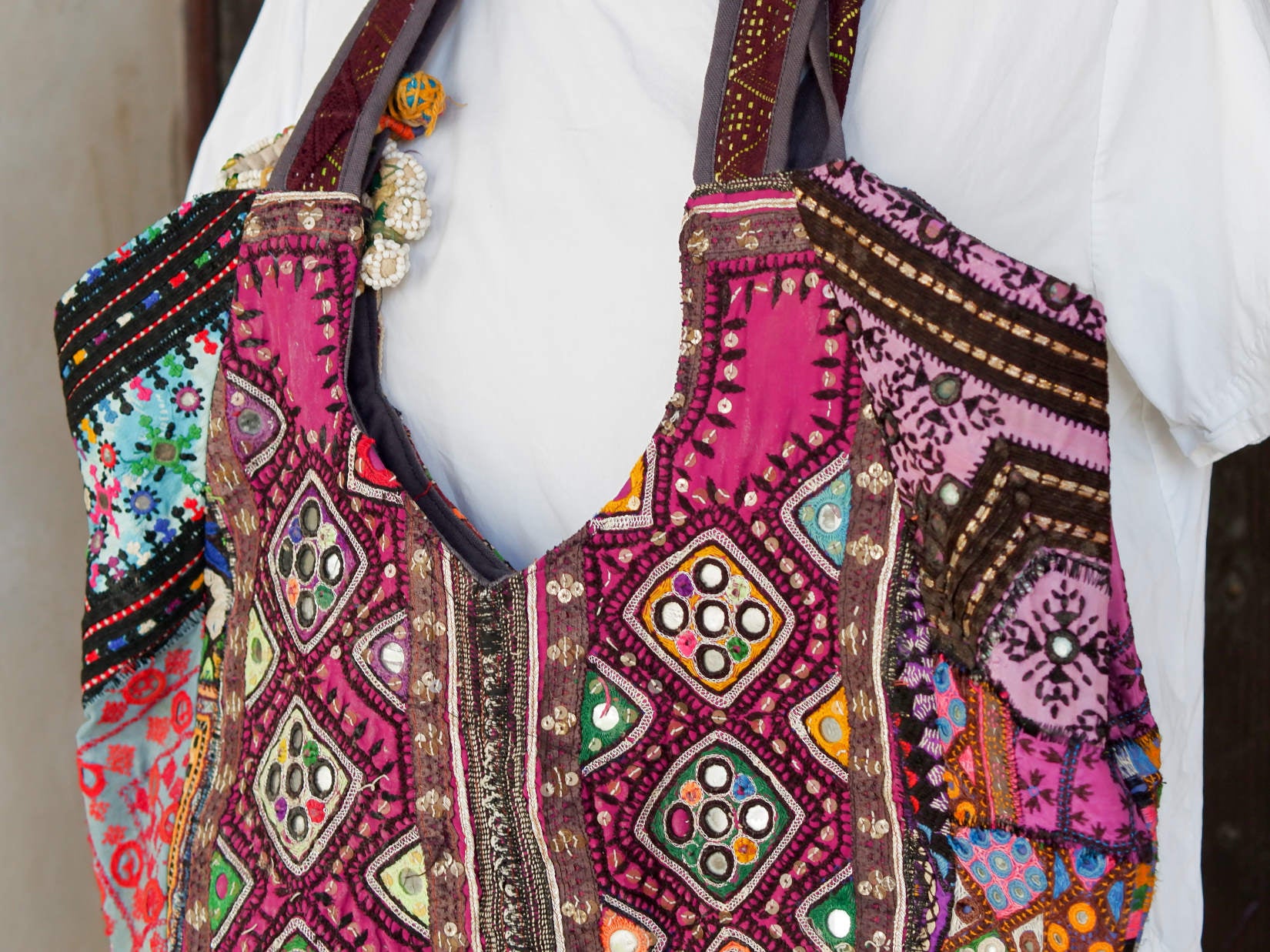 borsa indiana patchwork  tutti i pezzi che la compongono sono elementi in tessuto ricamati con specchietti ,pom pom, ecc... ricavati da vecchi tessuti rajasthani  pezzo unico lavorato interamente a mano chiusura a calamita ed interno foderato  lavorata in ogni angolo e lato .  50 x 35 x 15 cm esclusi manici manici 35 cm