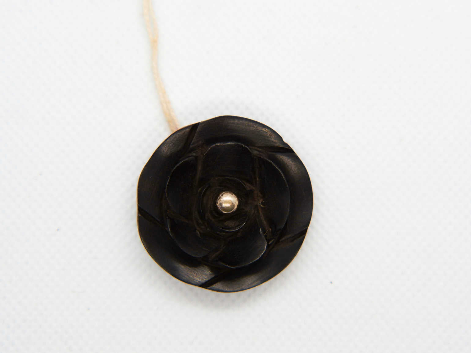 pendaglio in ebano nero intagliato a fiore con punto in argento  dimensione diametro 3 x 1 cm  peso 6,6 gr