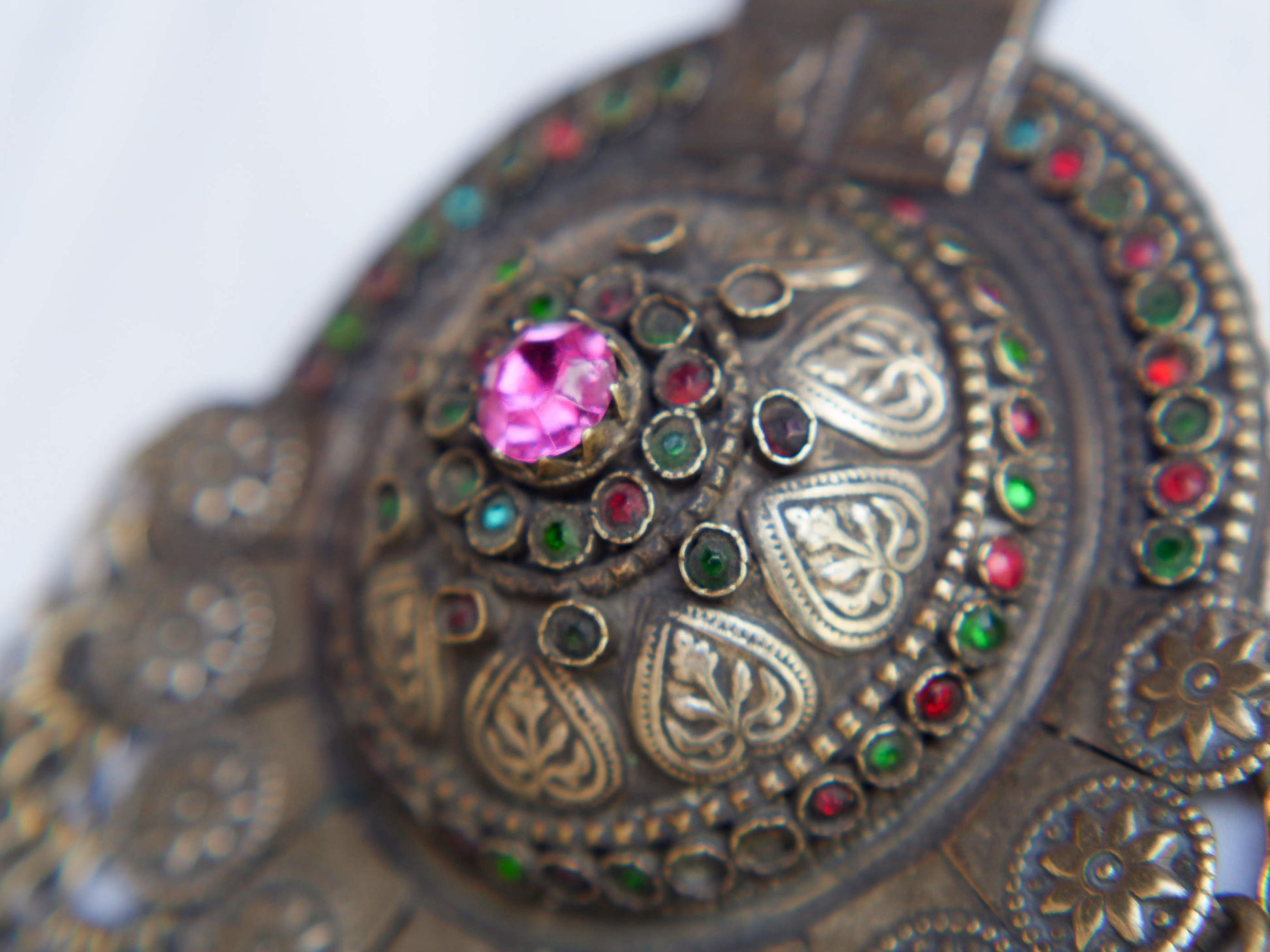 Questa lunga e massiccia collana proviene probabilmente da una delle tribù nomadi dell'Afghanistan o del Turkmenistan. Il ciondolo ha inscritto motivi floreali e boteh (paisley). Costruito in lega di argento, pezzo unico databile primi 900, conservato perfettamente, le catene che all'estremità hanno una sfera campanellino sono originali e incastrate a mano. Pezzo di difficile reperibilità.  lunghezza totale 20 cm, diametro parte superiore 10 cm, peso 170 gr