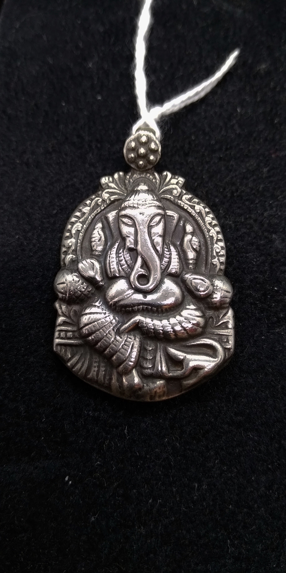 pendaglio in argento lavorato artigianalmente raffigurante ganesha , ganesh  divinità indiana  Formato dalle parole sanscrite gana (tanti, tutti) e isha (signore), Ganesha significa letteralmente "Signore dei gana" dove gana può essere interpretato come "moltitudine", facendo assumere al nome il significato di "Signore di tutti gli esseri", ma con gana nella tradizione induista si possono intendere anche dei piccoli demoni deformi che corteggiano Shiva Ganesha viene a volte chiamato anche Vighnesvara, "Sign