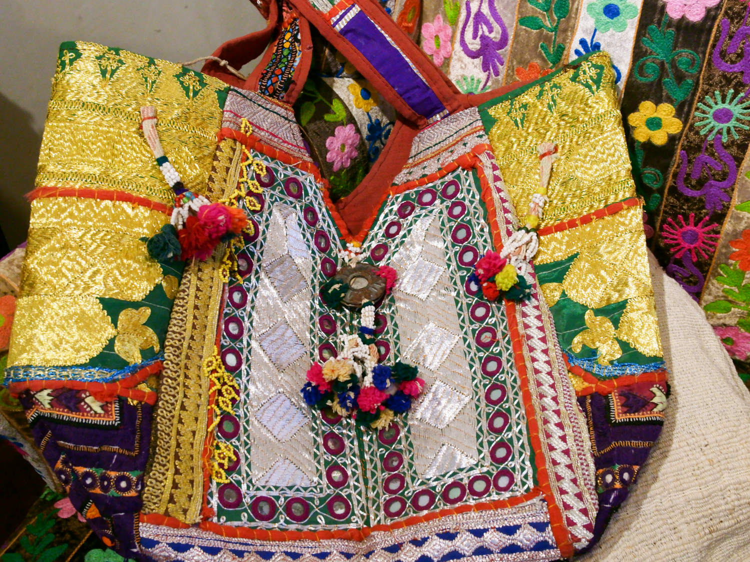 borsa indiana patchwork   tutti i pezzi che la compongono sono elementi in tessuto ricamati con specchietti , con ricamo ecc... ricavati da vecchi tessuti rajasthani   pezzo unico lavorato interamente a mano   filo oro e filo argento .   3 pon pon , apertura a cerniera ed interno foderato   lavorata in ogni angolo e lato .    50 x 40 x 17 cm esclusi manici manici 35 cm   per info ed ulteriori foto 0039 3338778241 info@etniko.it www.etniko.it