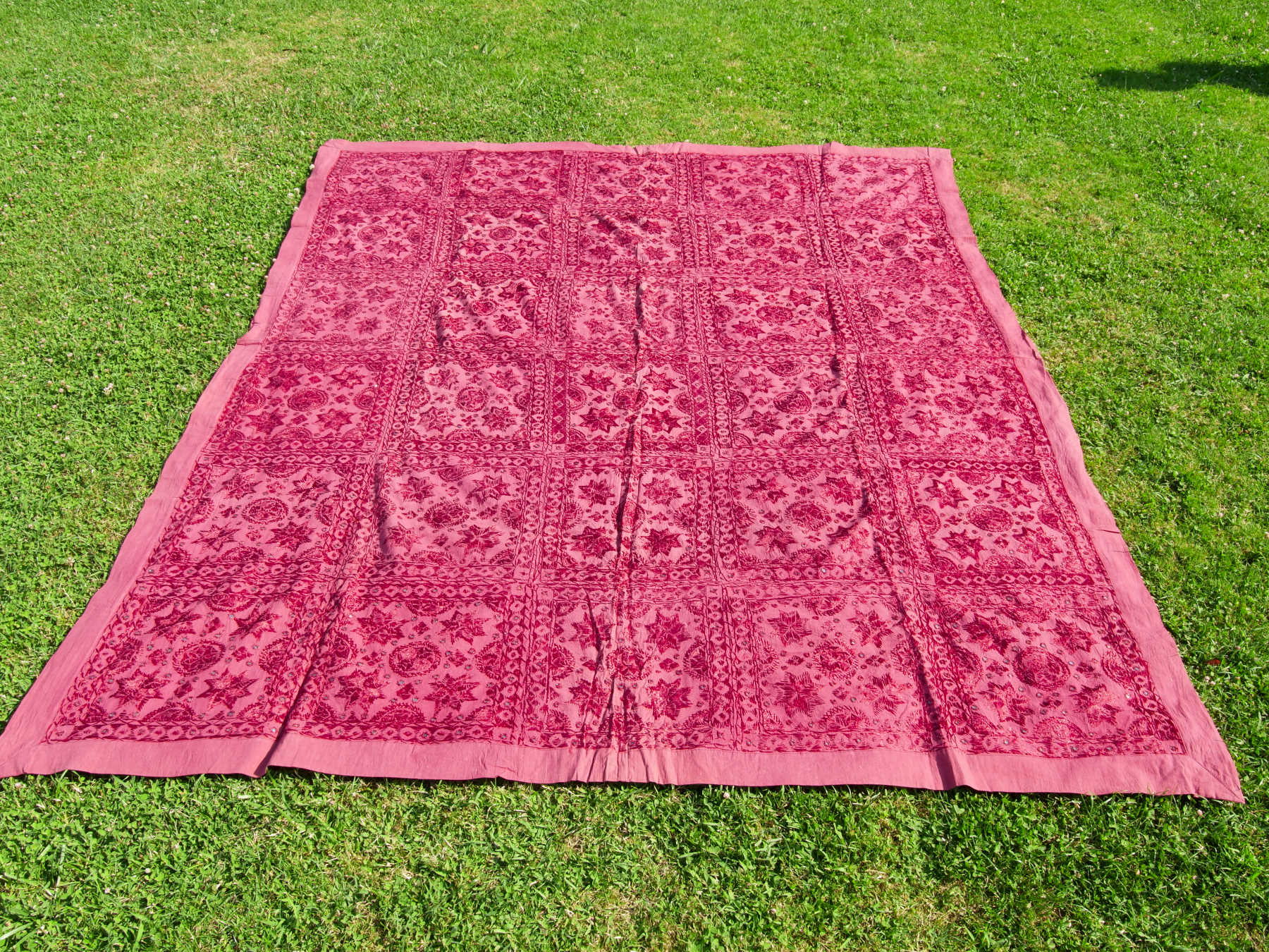 Telo Indiano in cotone doppio strato, ricamato tono su tono con specchietti,  di color rosso. Può essere impiegato come copridivano, copriletto, tovaglia o tessuto da appendere a parete. Dimensioni 210x245cm