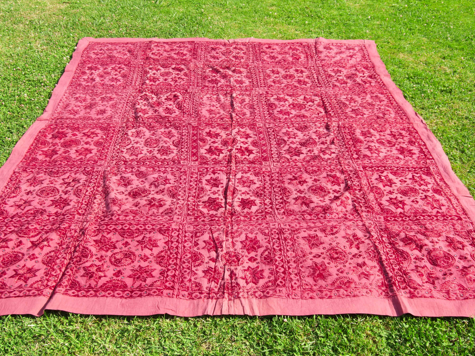 Telo Indiano in cotone doppio strato, ricamato tono su tono con specchietti,  di color rosso. Può essere impiegato come copridivano, copriletto, tovaglia o tessuto da appendere a parete. Dimensioni 210x245cm